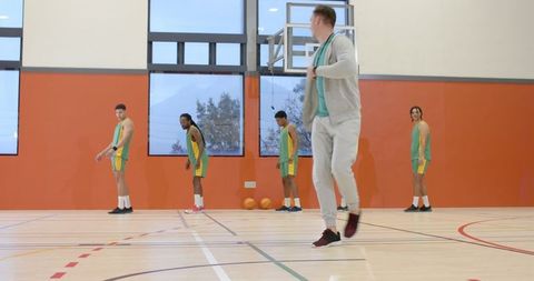 Basketball Coach Demonstrating Fitness Ritual in Gymnasium