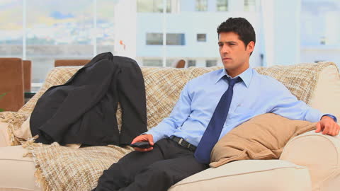 Exhausted Businessman Relaxing on Sofa After Work