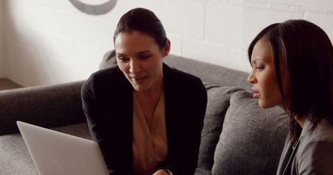 Diverse Business Professionals Collaborating on Laptop Project