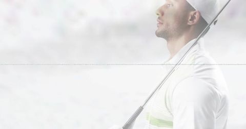 Contemplative male golfer holding club across shoulder in high-key profile with copy space