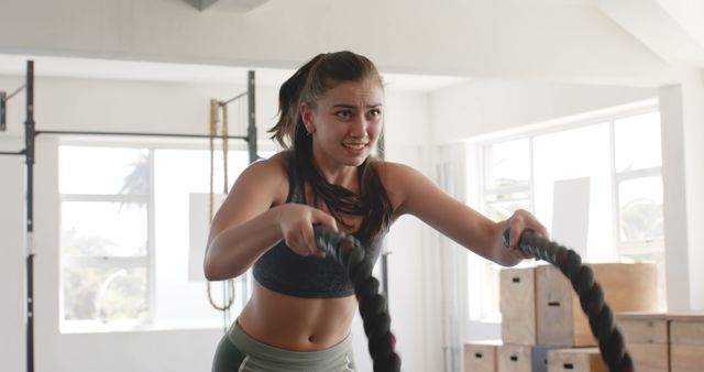 Determined Woman Exercising with Battle Ropes in Gym - Download Free Stock Images Pikwizard.com