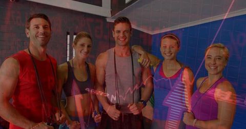 Group fitness instructors embracing team spirit in gym environment