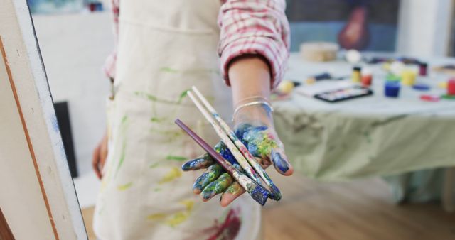 Artist Holding Paintbrushes with Paint-Stained Hands in Art Studio - Download Free Stock Images Pikwizard.com