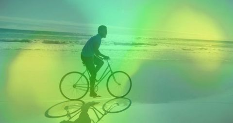 Cyclist Riding Along Calm Beach at Sunset in Vibrant Overlay