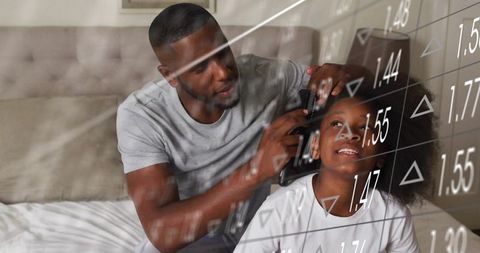Black Father Trimming Daughter Hair at Home with Financial Data Overlay, Home Care Bonding