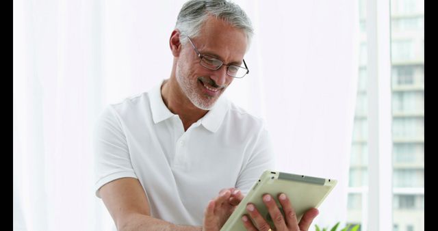 Smiling man using his tablet in fitness room
