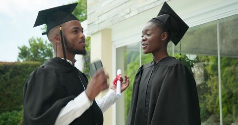 African american graduates celebrating achievement outdoors