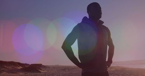 Silhouetted Man Stretching on Beach with Sun Flares - Download Free Stock Images Pikwizard.com