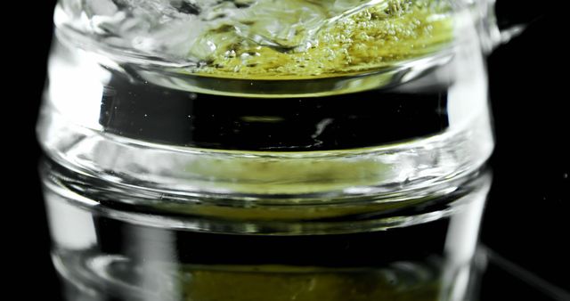 Close-up shot of a beer in a glass with its reflection on a glossy black surface. Tiny bubbles and golden liquid create a visually appealing texture. This could be used for advertising alcoholic beverages, blog posts about drinks, or any content related to social gatherings and celebrations.