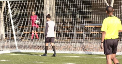 Young Soccer Player Behind Goal Net During Game