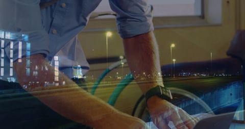 Business professional typing on laptop with city lights overlay