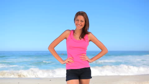 Joyful Woman Standing by Ocean on Sunny Beach Day