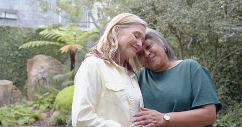 Senior Females Embracing Outdoors Amid Ferns and Stones