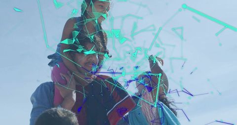 Family carrying child on shoulders with turquoise geometric glitch overlay