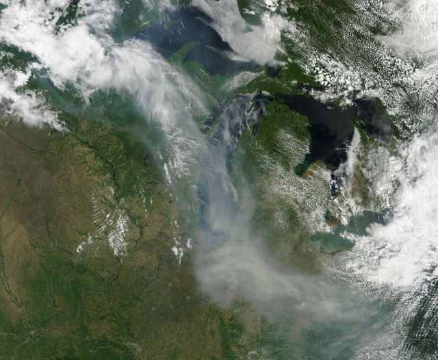 This powerful satellite image shows smoke from Canadian wildfires drifting over Lake Michigan and nearby states, including Minnesota, Wisconsin, Indiana, and Ohio. Captured by the MODIS instrument on the Terra satellite, this natural-color image visualizes the extensive spread of smoke and its potential implications for air quality. Useful for environmental awareness campaigns, educational material on the impact of wildfires, and scientific research on air pollution.