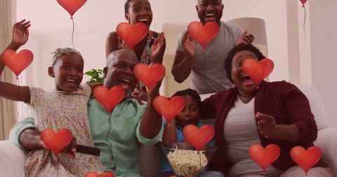 Happy Family Cheering with Popcorn and Heart Balloons Overlay