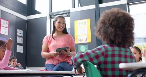 Teacher Using Tablet Engages Children in Interactive Classroom Lesson