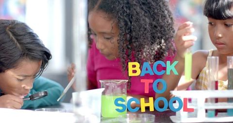 Children conducting colorful chemistry experiment in classroom with back to school letters