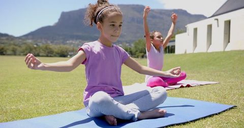 Diverse Children Practicing Yoga Outdoors in Sunny Park