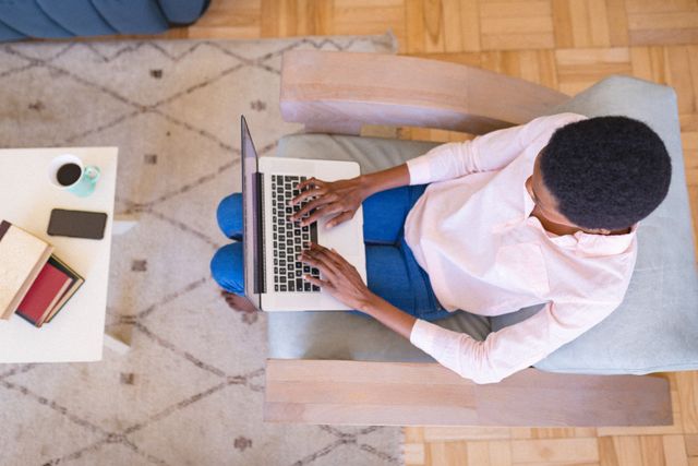 High angle view of african american businesswoman using laptop while working remotely from home. unaltered, home office, business, freelancer and technology concept.