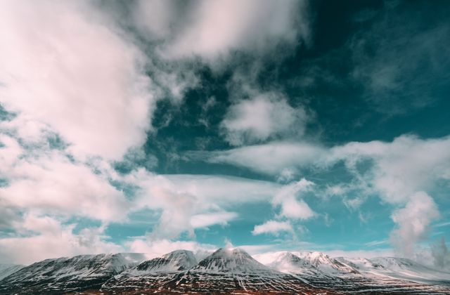 This image captures snow-capped mountains under a dramatic, cloud-filled sky. Ideal for travel blogs, tourism advertisements, nature posters, and outdoor adventure promotions.