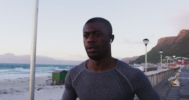 Focused Young Man Jogging on Scenic Beach Pier at Sunrise - Download Free Stock Images Pikwizard.com