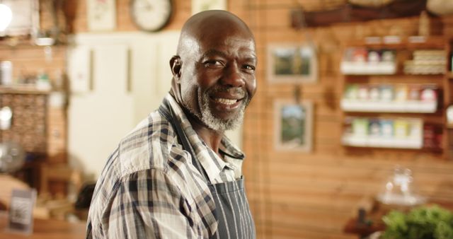 Smiling Mature Man in Plaid Shirt and Apron Standing in Cozy Workshop - Download Free Stock Images Pikwizard.com