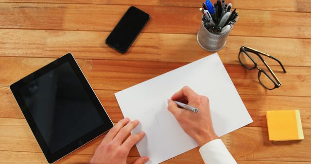 Person Drawing on White Paper at Office Desk with Tablet and Stationery - Download Free Stock Images Pikwizard.com