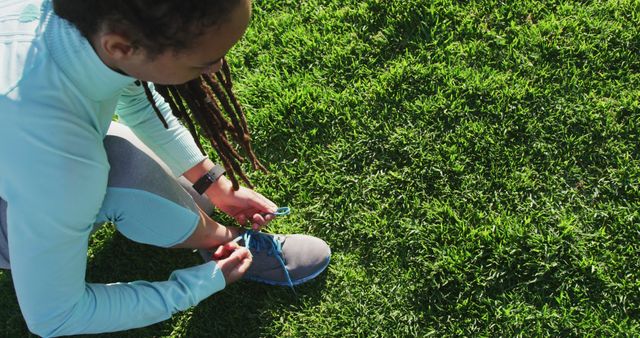 Woman Tying Running Shoes on Grass Field - Download Free Stock Images Pikwizard.com