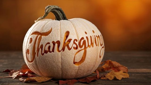 Cream pumpkin carved thanksgiving script glowing centerpiece on rustic wood table