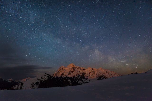 Featuring a majestic night sky with countless stars and the Milky Way galaxy, this scene showcases snow-capped mountain peaks bathed in moonlight. Ideal for use in nature magazines, promotional tourism materials, outdoor adventure presentations, and inspirational backgrounds.