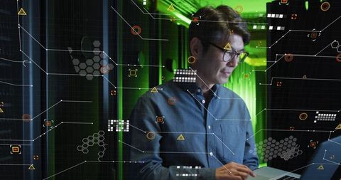 It technician reviewing data in server room with digital interface display