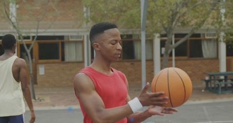 Young athlete handling basketball on urban outdoor court practicing ball control and focus