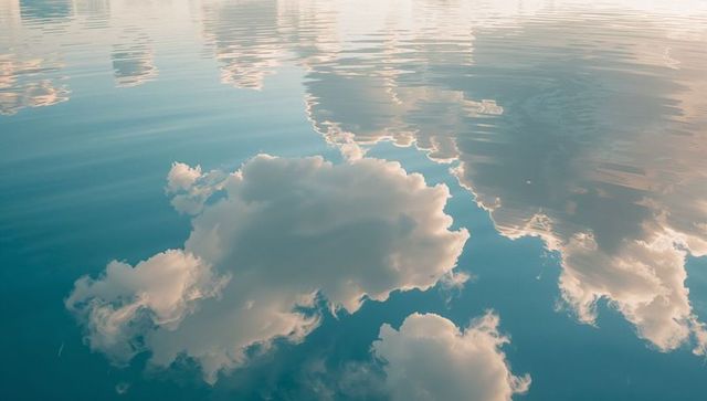 Serene Cloud Reflections on Tranquil Water Surface
