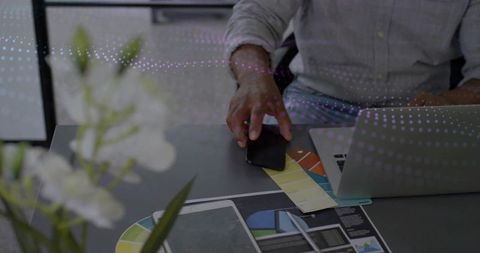 Designer choosing colors in modern workspace with laptop and swatch