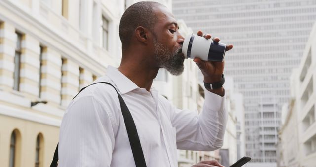 Businessman Drinking Coffee While Checking Phone In Urban Setting - Download Free Stock Images Pikwizard.com