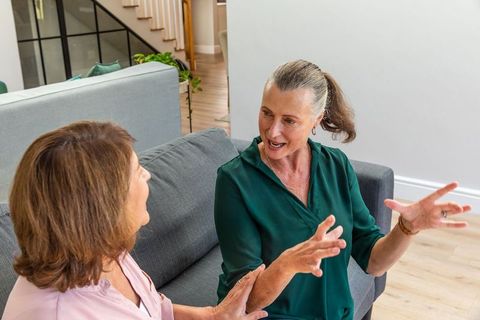 Senior Friends Engaging in Animated Conversation on Cozy Couch