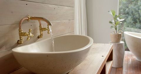 Elegant washbasin with flowing water creating tranquil bathroom ambiance