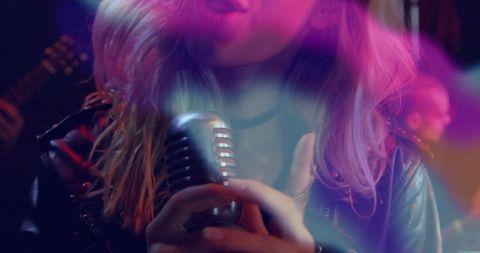 Singer Gripping Vintage Microphone Onstage During Rock Performance