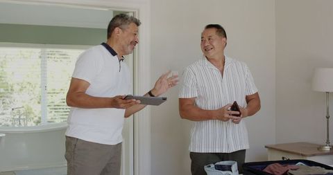 Senior Friends Packing for Vacation in Cozy Home