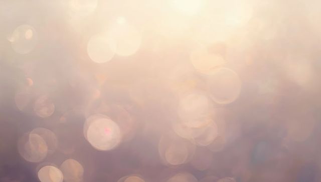 Soft warm bokeh background with pastel light orbs and dreamy golden lens flare