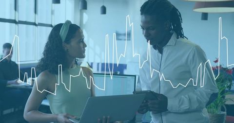 Colleagues Analyzing Data on Laptop and Tablet with Line Graph Overlay in Open Office