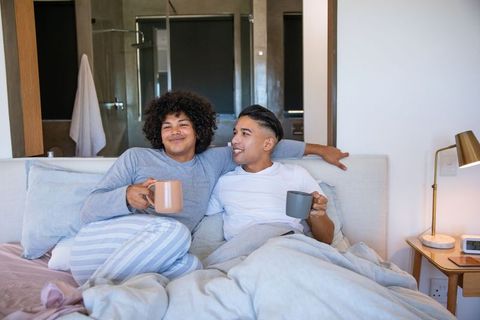 Comfortable morning with coffee in bed for joyful couple
