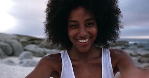 Joyful African American Woman Dancing on Beach at Sunset