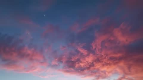 Shifting Crimson Clouds at Twilight Revealing Twinkling Star Over Horizon