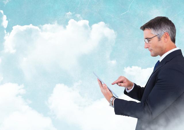 Businessman interacting with tablet against a cloudy sky background. Ideal for topics on modern business, digital technology, cloud computing, and entrepreneurship in marketing and promotional materials. Suitable for illustrating business concepts in presentations or articles related to technological advancements in professional environments.