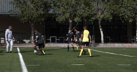 Soccer Players Deep in Strategic Team Practice on Sunny Field