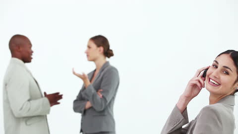 Businesswoman Enjoying Call with Colleagues in Background