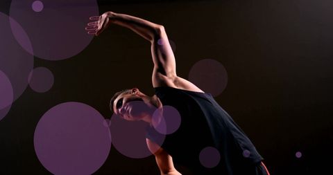 Fit Caucasian Male Stretching in Dark Gym Setting