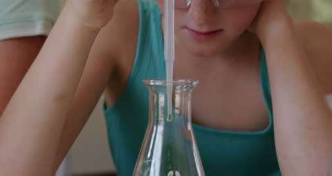 Young Girl Engaged in Science Experiment Using Pipette and Beaker